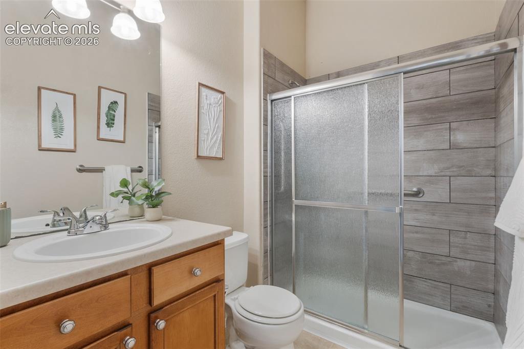 Image 23 of 50: Integrated vanity with a single basin sink, wood-finish cabinetry, and a sh