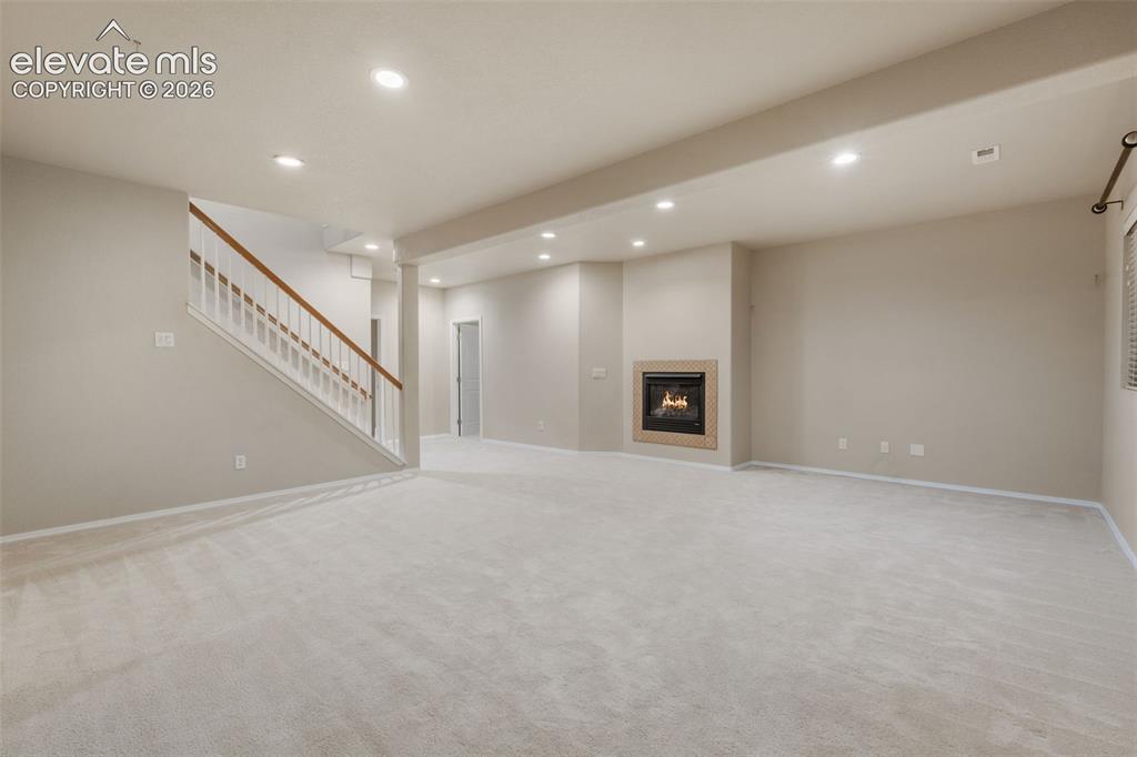 Image 25 of 50: Spacious room with light-toned carpeting, recessed lighting, and an integra