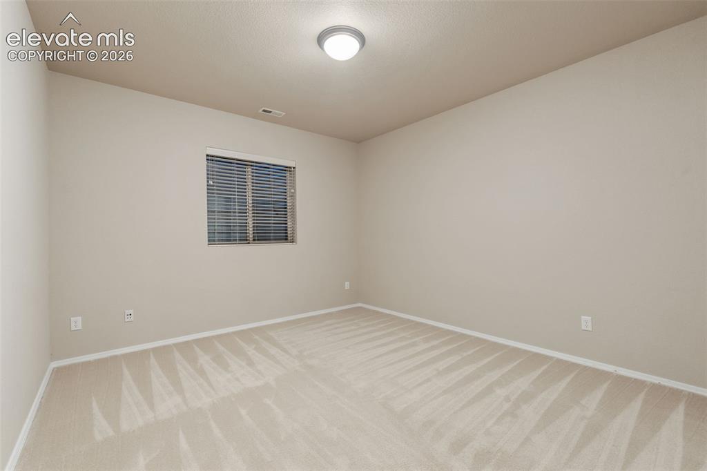 Image 29 of 50: Neutral wall finishes with a single window featuring horizontal blinds