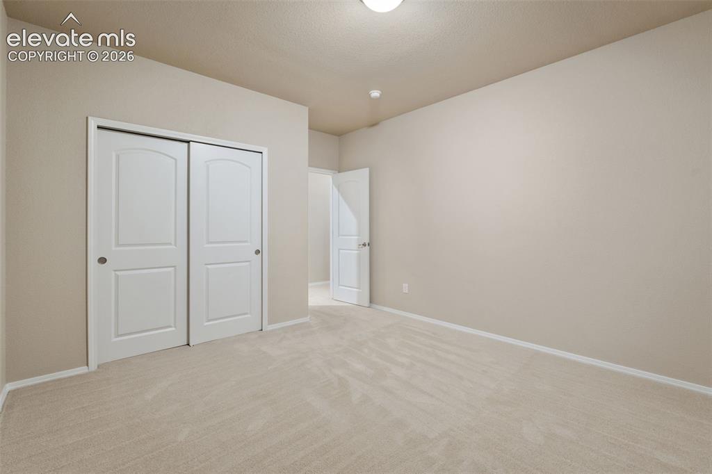 Image 30 of 50: Carpeted room featuring a double-door closet with arched paneling and a flu
