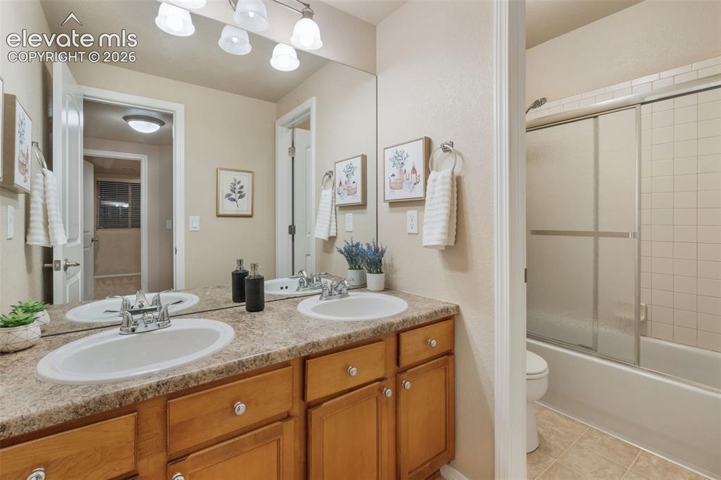 Image 31 of 50: Dual vanity with chrome fixtures and light wood-finish cabinetry