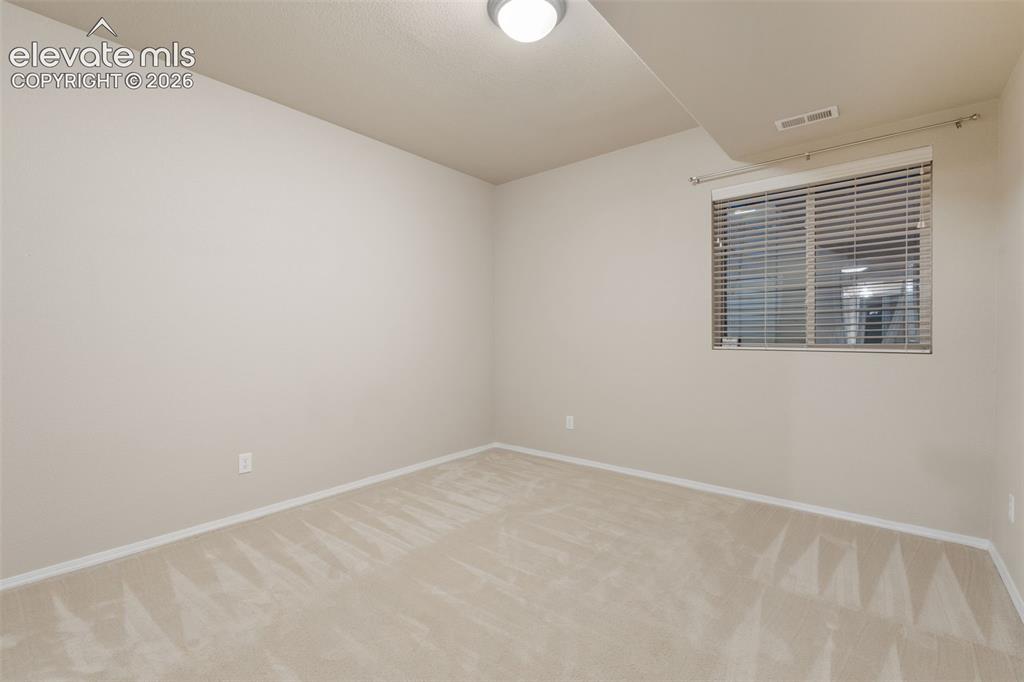 Image 32 of 50: Wall-to-wall carpeting, neutral wall color, and a window with horizontal bl