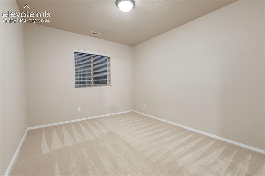 Image 34 of 50: Soft neutral wall paint, carpeted flooring, window with blinds, and ceiling