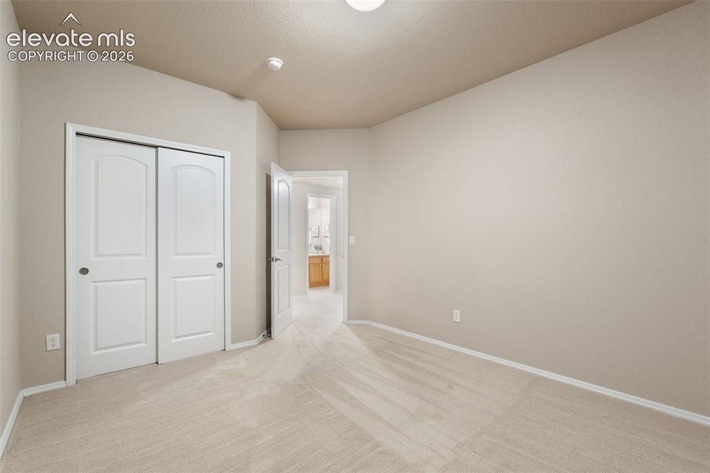 Image 35 of 50: Neutral wall finishes, vaulted ceiling, and light-toned carpeting