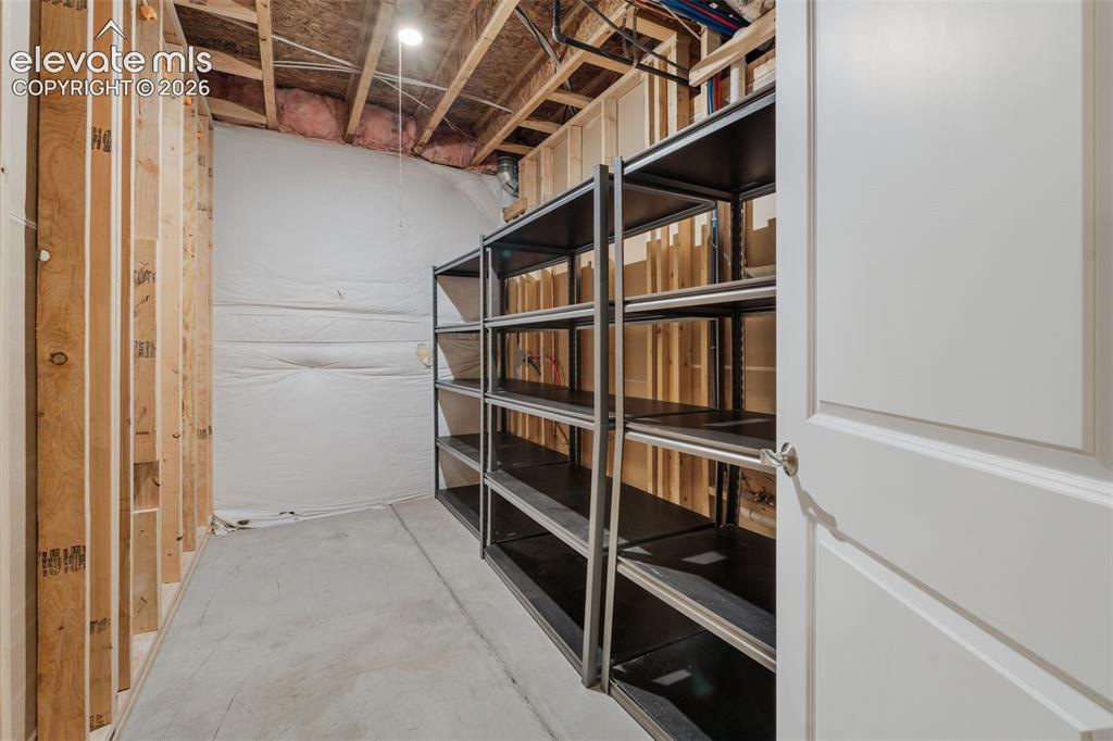 Image 37 of 50: Unfinished basement area featuring framed walls, exposed ceiling joists, co