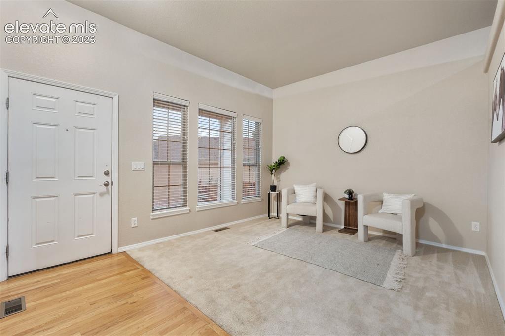 Image 7 of 50: Vaulted ceiling, three large windows with blinds, light-toned wall paint, n