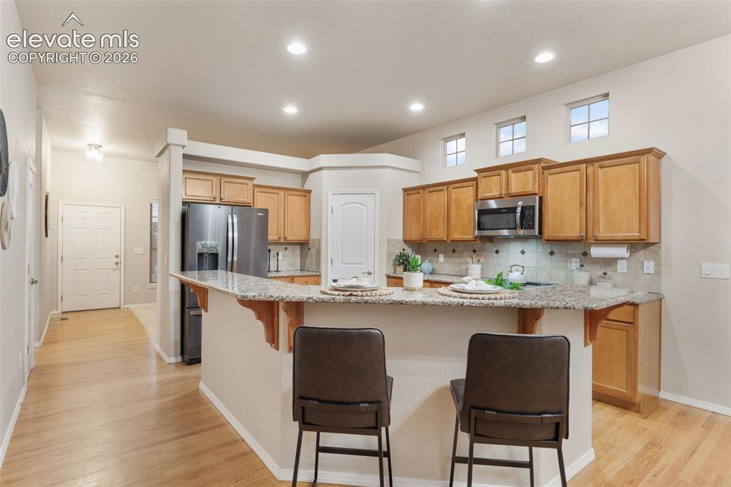 Image 9 of 50: Kitchen featuring light wood cabinetry, granite countertops, stainless stee
