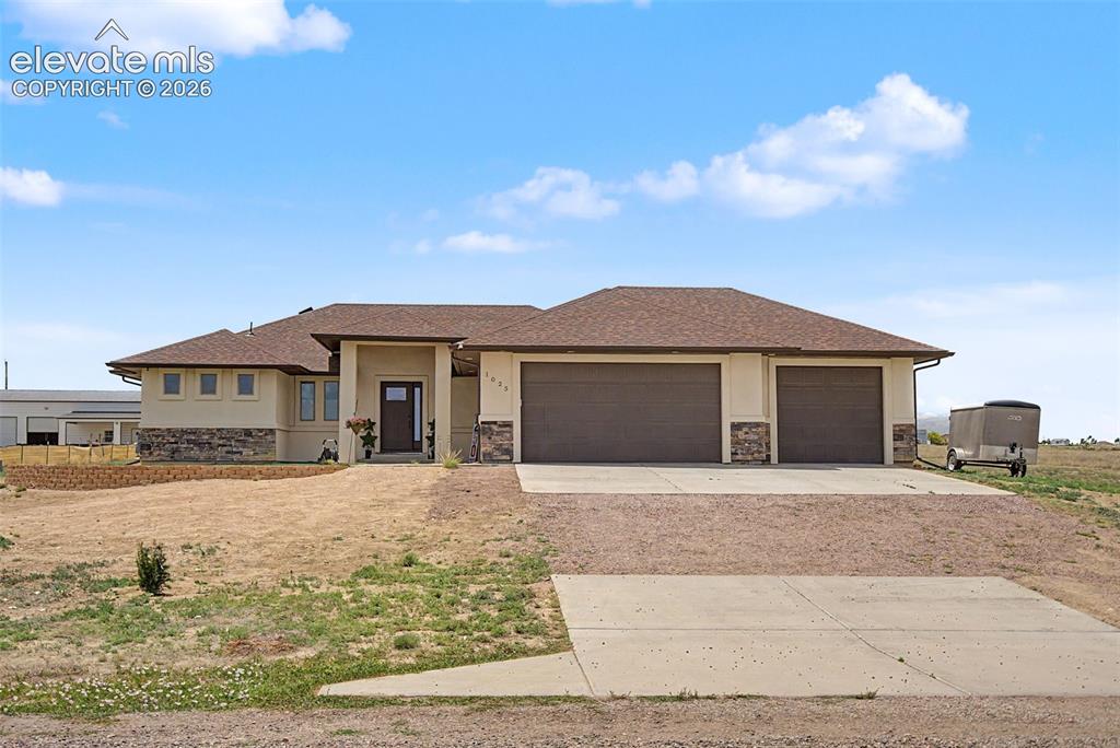 Image 1 of 47: Contemporary ranch-style home featuring a stucco and stone veneer exterior