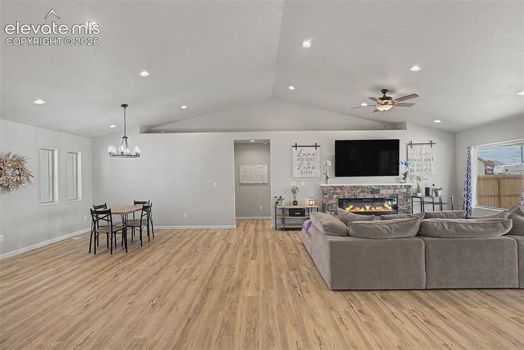 Image 15 of 47: Spacious living area featuring vaulted ceilings, recessed lighting, and woo