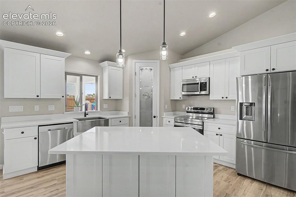 Image 17 of 47: Kitchen featuring white cabinetry, stainless steel appliances, a center isl