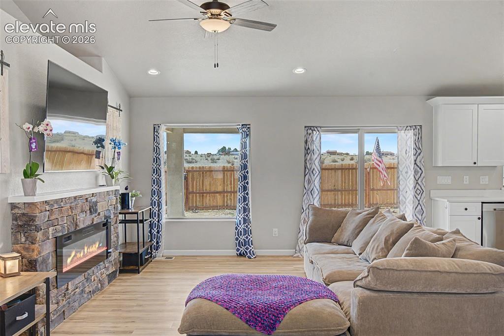 Image 19 of 47: Open-concept living area with vaulted ceilings, recessed lighting, and wood