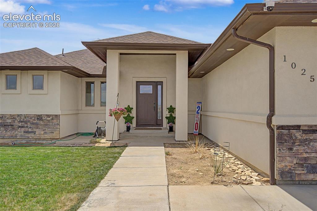 Image 2 of 47: Contemporary stucco exterior featuring a stone accent foundation