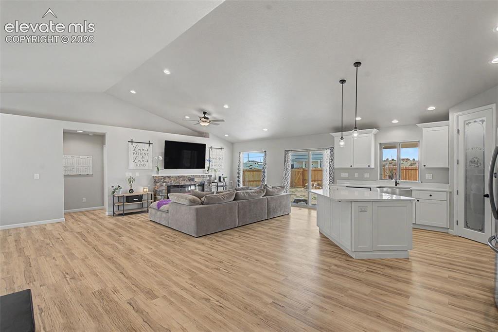 Image 20 of 47: Open-concept living space featuring wood-finish flooring, a vaulted ceiling
