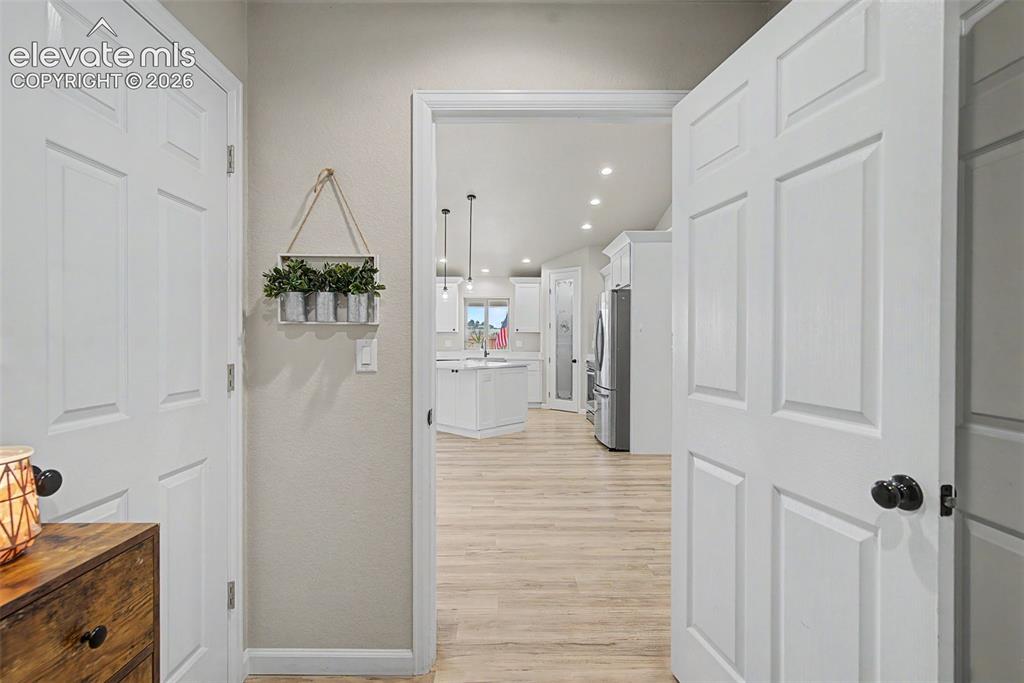 Image 21 of 47: Open-concept living area with vaulted ceilings, recessed lighting, and wood
