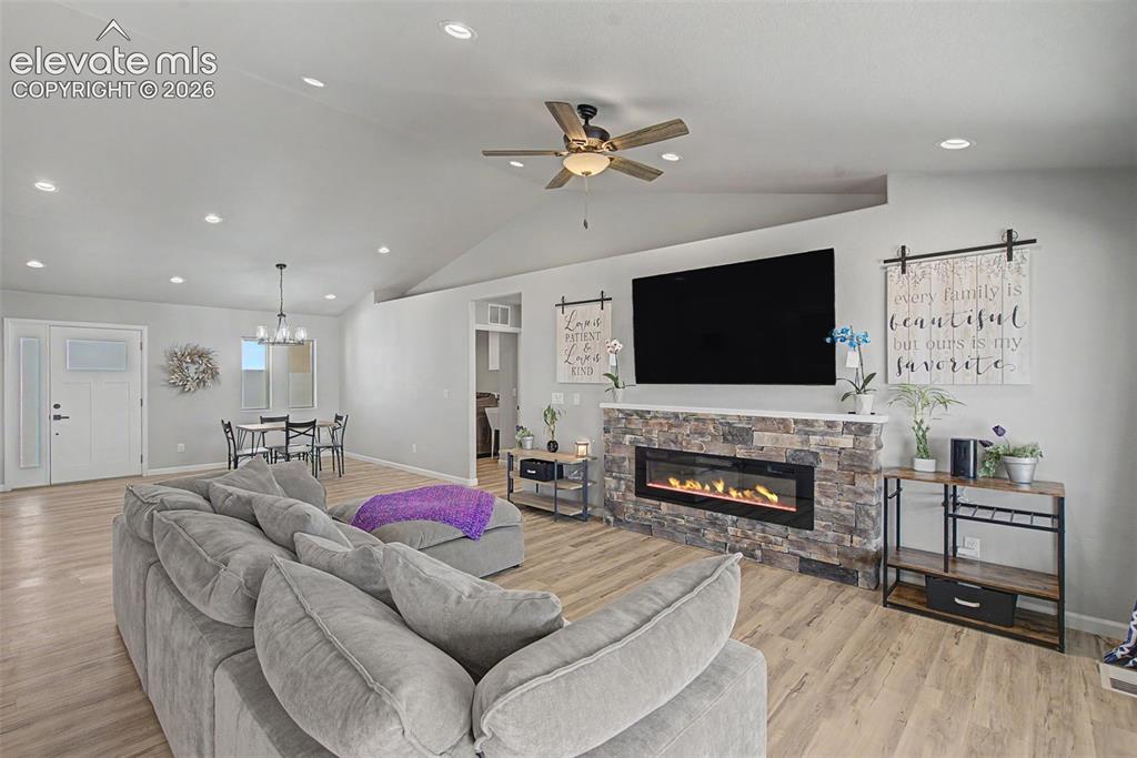 Image 22 of 47: Living room featuring wood-finish flooring, a stone-faced electric fireplac