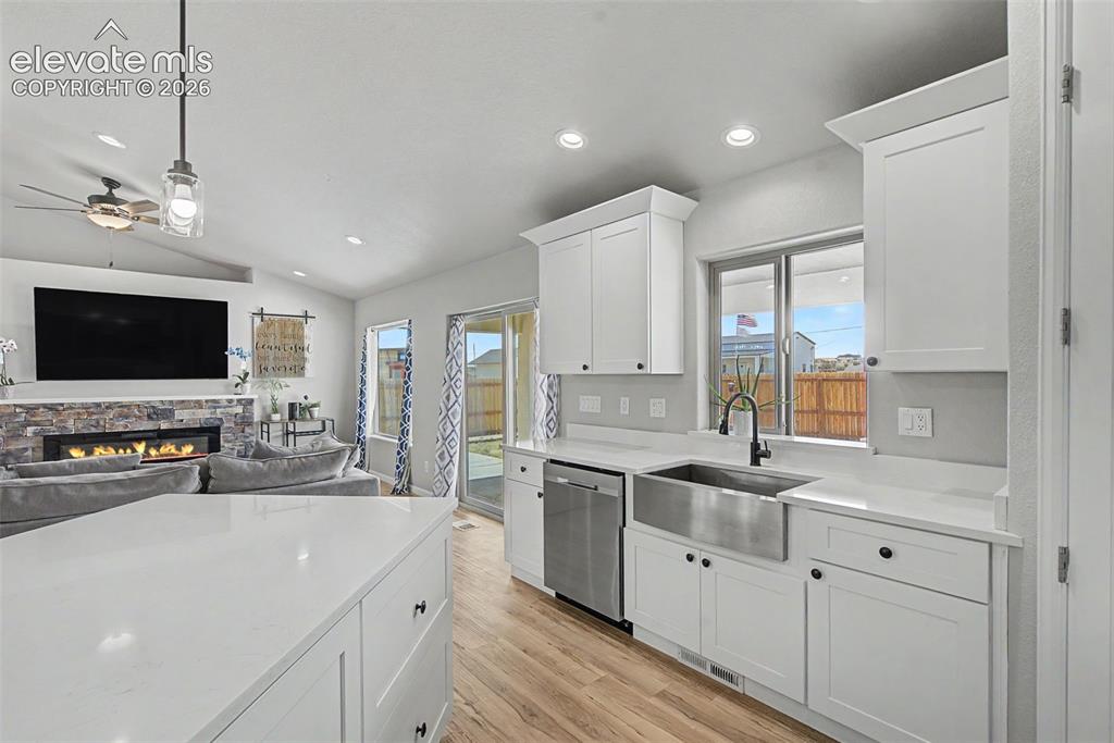 Image 24 of 47: Open-concept kitchen with white cabinetry and light-toned countertops