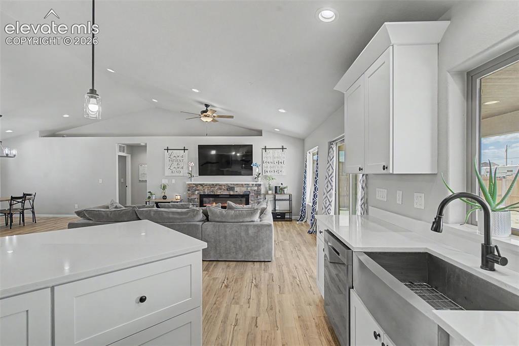 Image 26 of 47: Kitchen island with white shaker cabinetry and a solid surface countertop