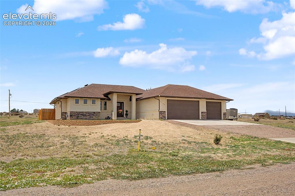 Image 3 of 47: Contemporary single-story residence featuring a stucco exterior with stone 