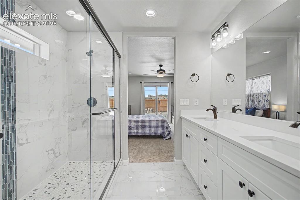 Image 32 of 47: Spacious bathroom featuring a dual vanity with white cabinetry, a large mir