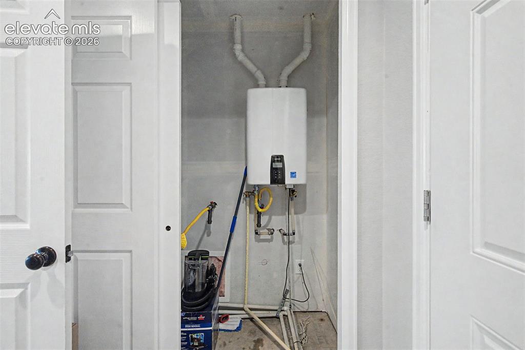 Image 40 of 47: Built-in mechanical closet featuring a wall-mounted tankless water heater, 