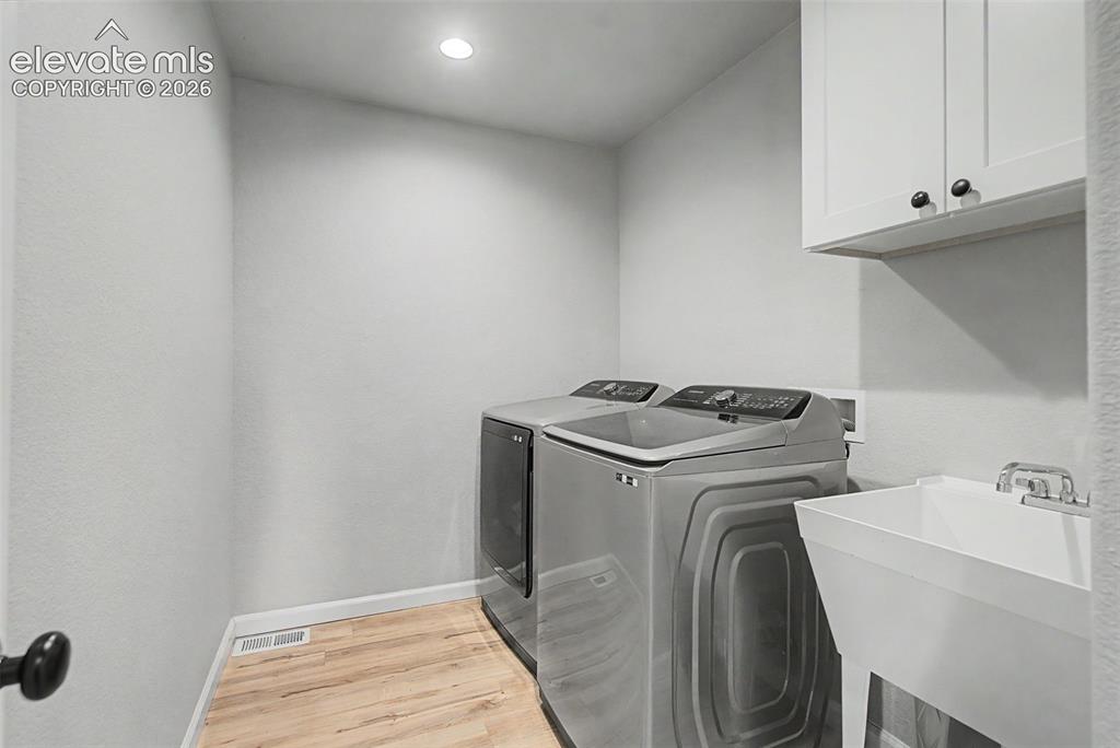 Image 41 of 47: Dedicated utility area featuring wood-finish flooring, recessed lighting, a