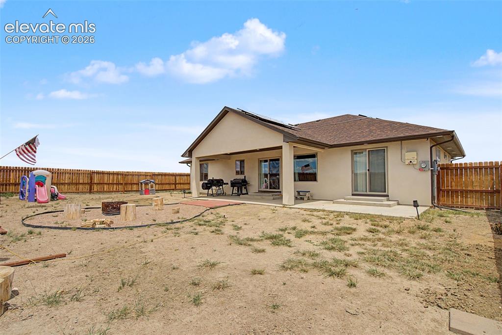Image 44 of 47: Rear exterior featuring a covered patio, a separate concrete patio, and a w