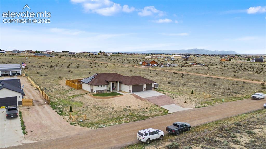 Image 5 of 47: Ranch-style residence featuring a tan stucco exterior, a brown shingle roof