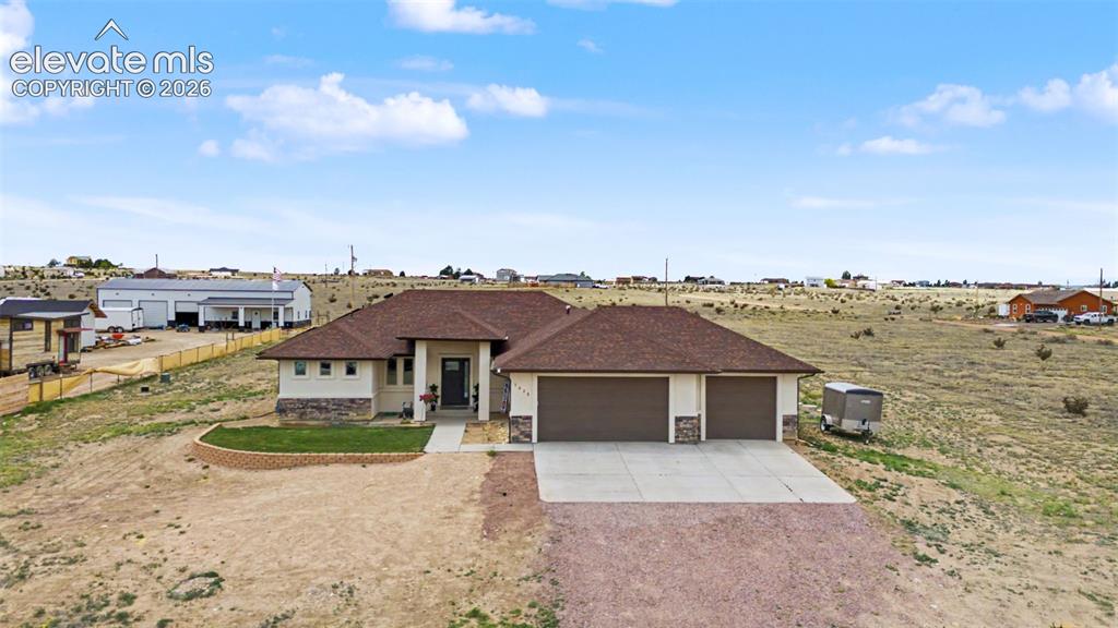 Image 7 of 47: Contemporary ranch-style exterior featuring a two-car garage, stone accent 