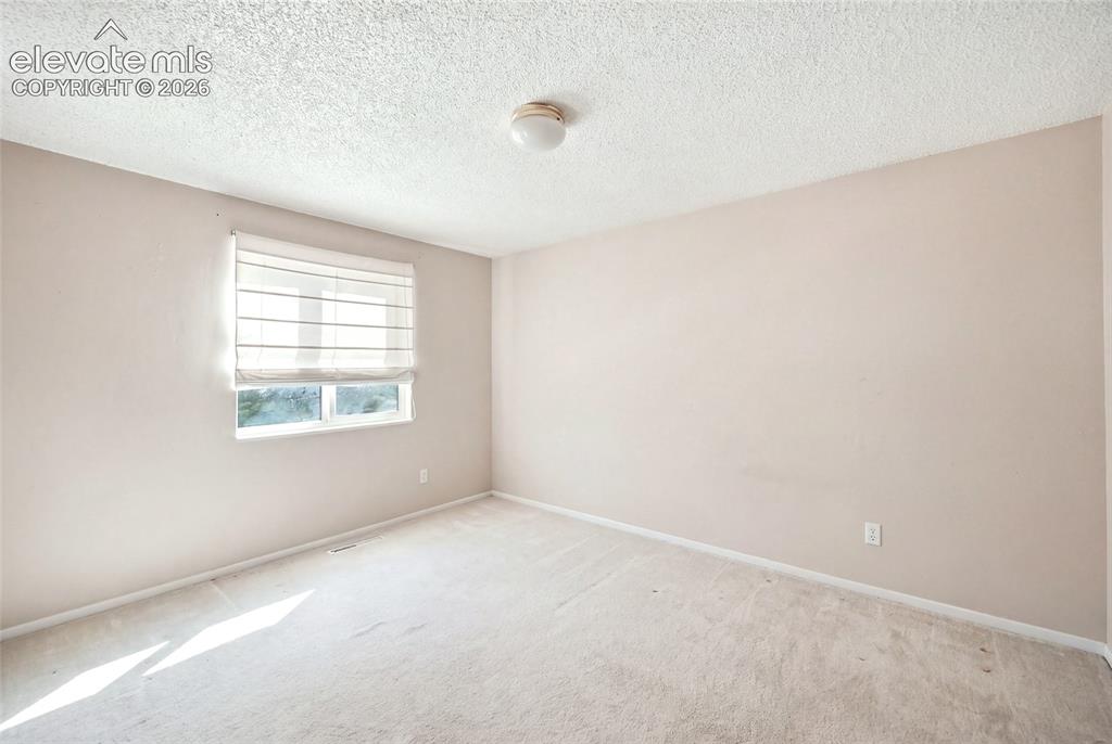 Image 21 of 39: Upper level bedroom. AI removed items from picture. Room shown here may n