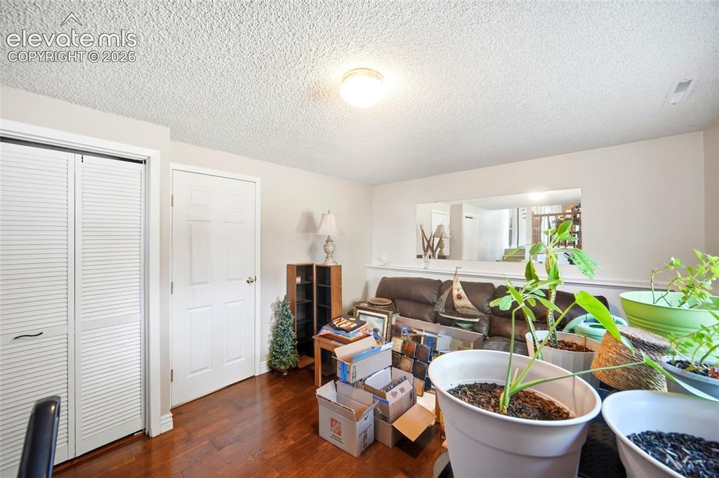 Image 25 of 39: Lower level family room with wood flooring