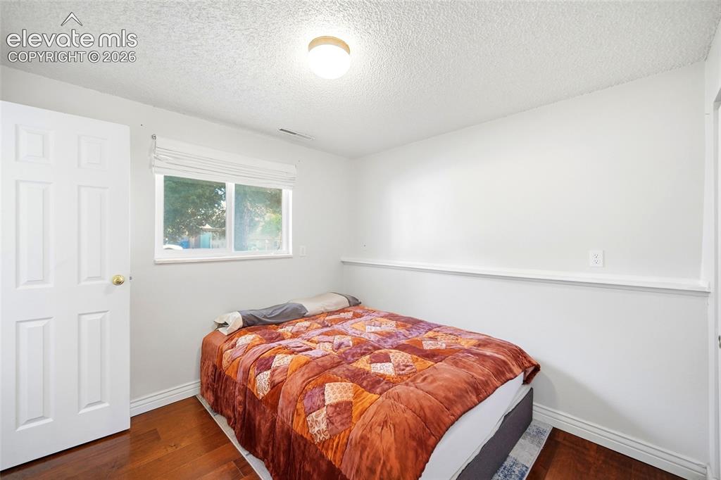 Image 28 of 39: Lower level bedroom with wood flooring