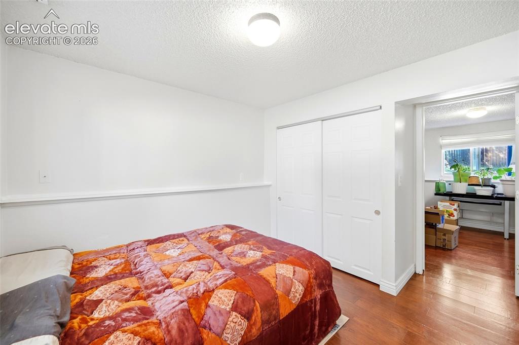 Image 29 of 39: Lower level bedroom with wood flooring