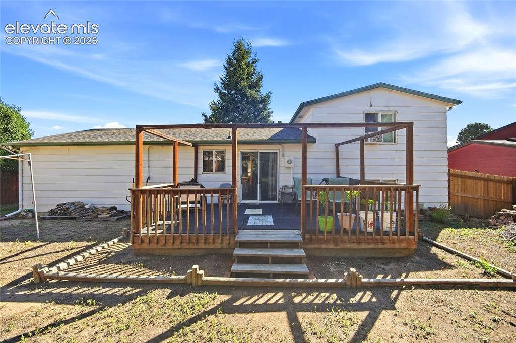 Image 34 of 39: Rear yard showing large wooden deck