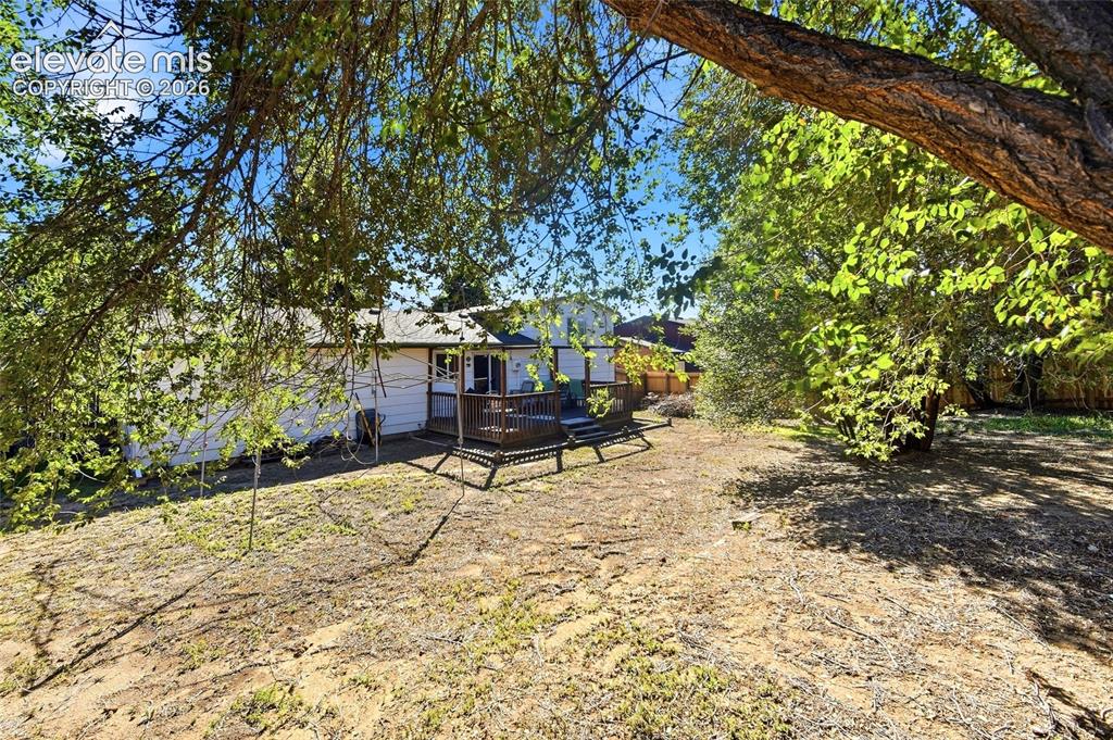 Image 36 of 39: Rear yard facing house, mature trees