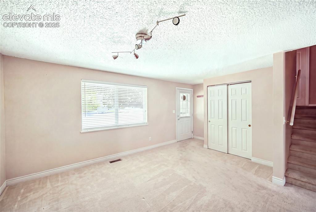 Image 5 of 39: Main level living room with no furnishings, ample storage in coat closet. C