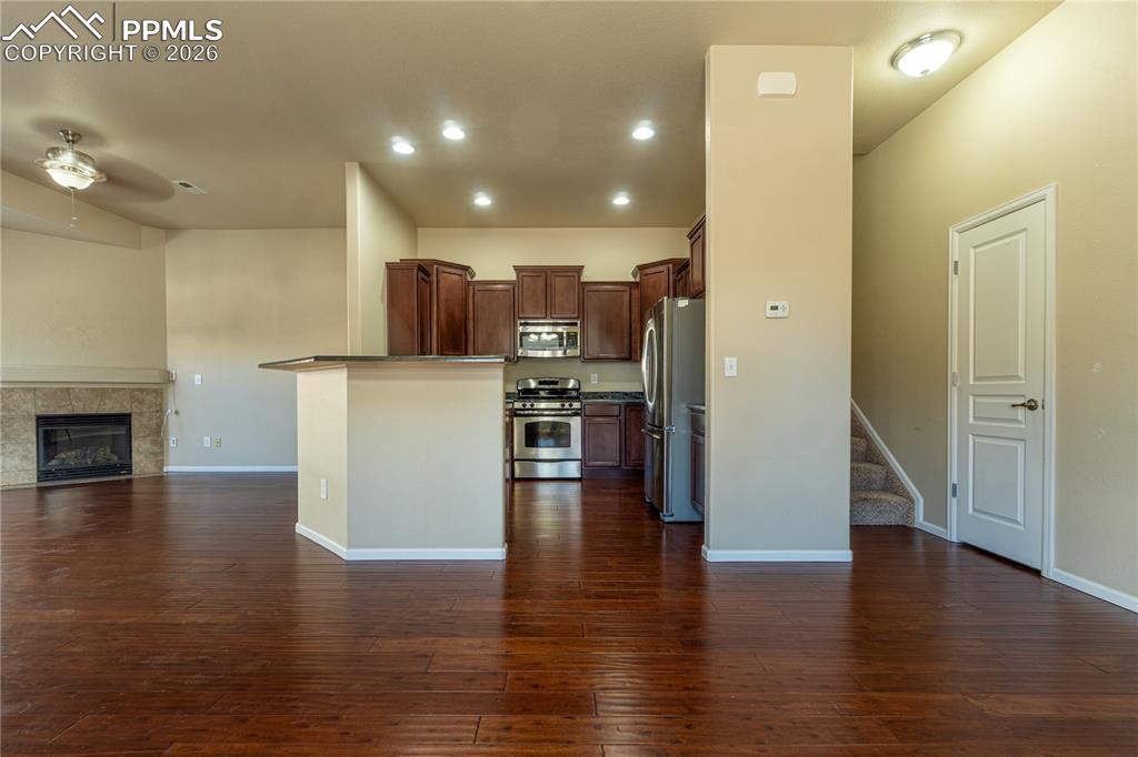 Image 10 of 33: Kitchen with open floor plan, stainless steel appliances, ceiling fan, a fi