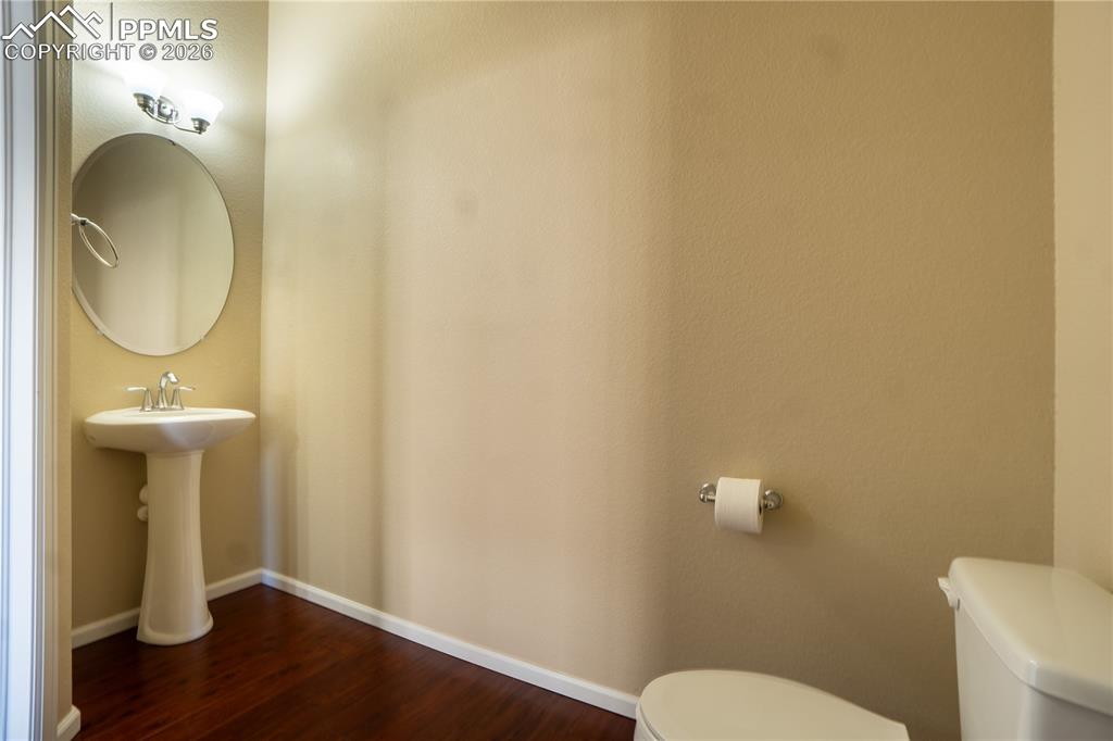 Image 14 of 33: Bathroom with toilet and dark wood-style flooring