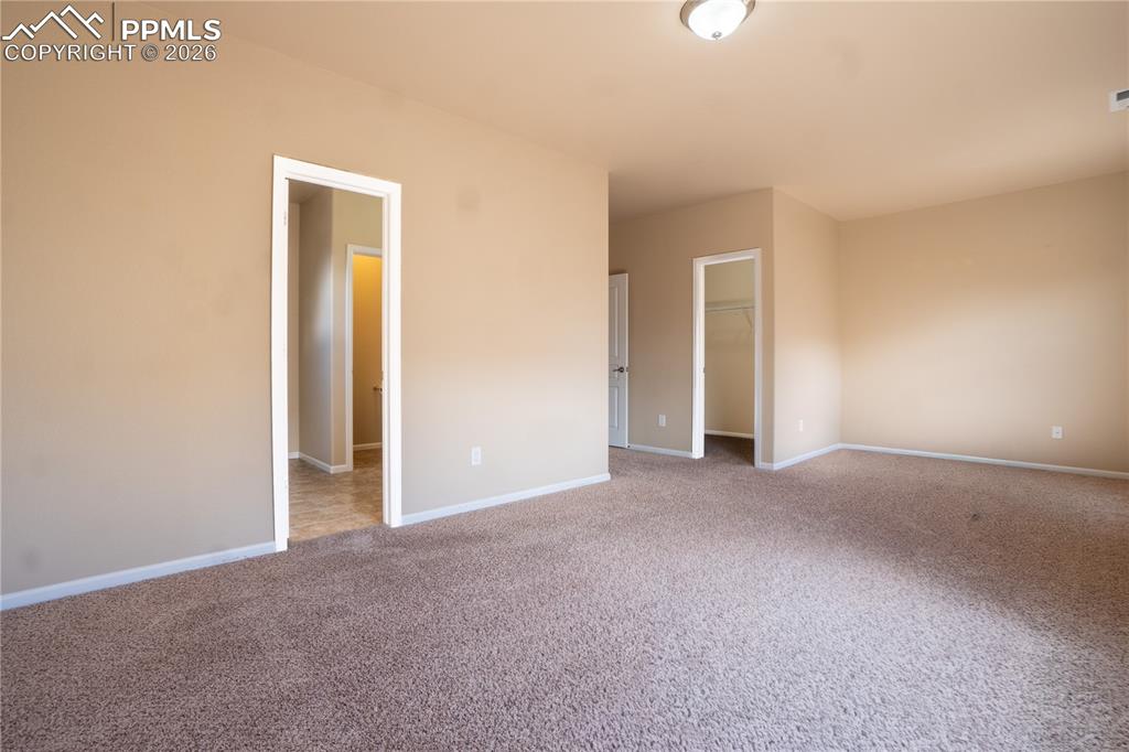 Image 24 of 33: Unfurnished bedroom with a spacious closet and carpet floors
