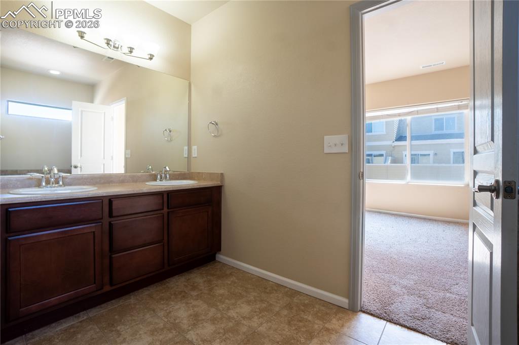 Image 28 of 33: Full bathroom with double vanity, plenty of natural light, and light colore