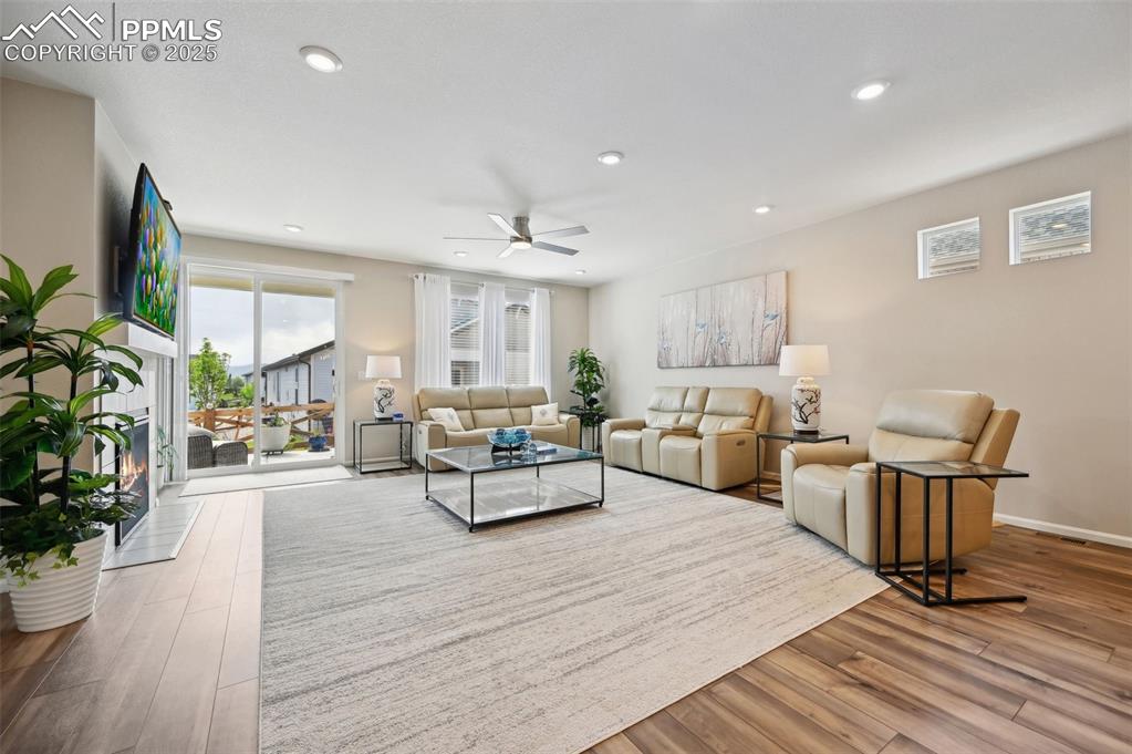 Image 13 of 44: Living area with wood finished floors, a ceiling fan, recessed lighting, an