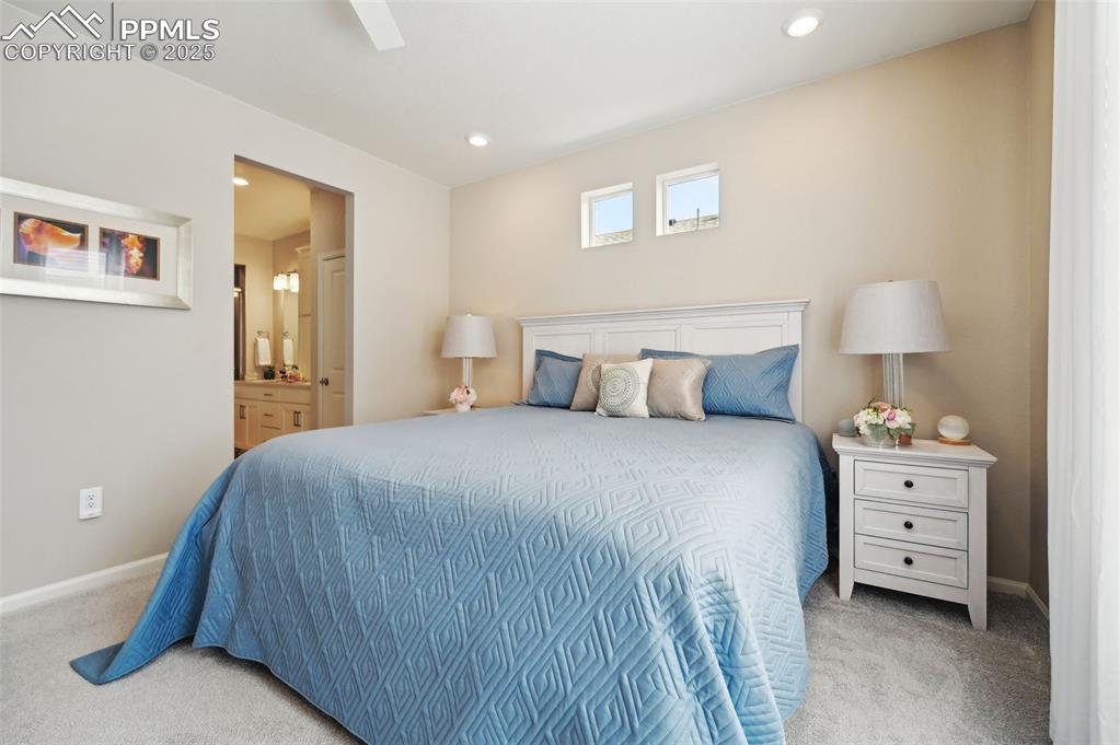 Image 16 of 44: Carpeted bedroom with baseboards, recessed lighting, and ensuite bathroom
