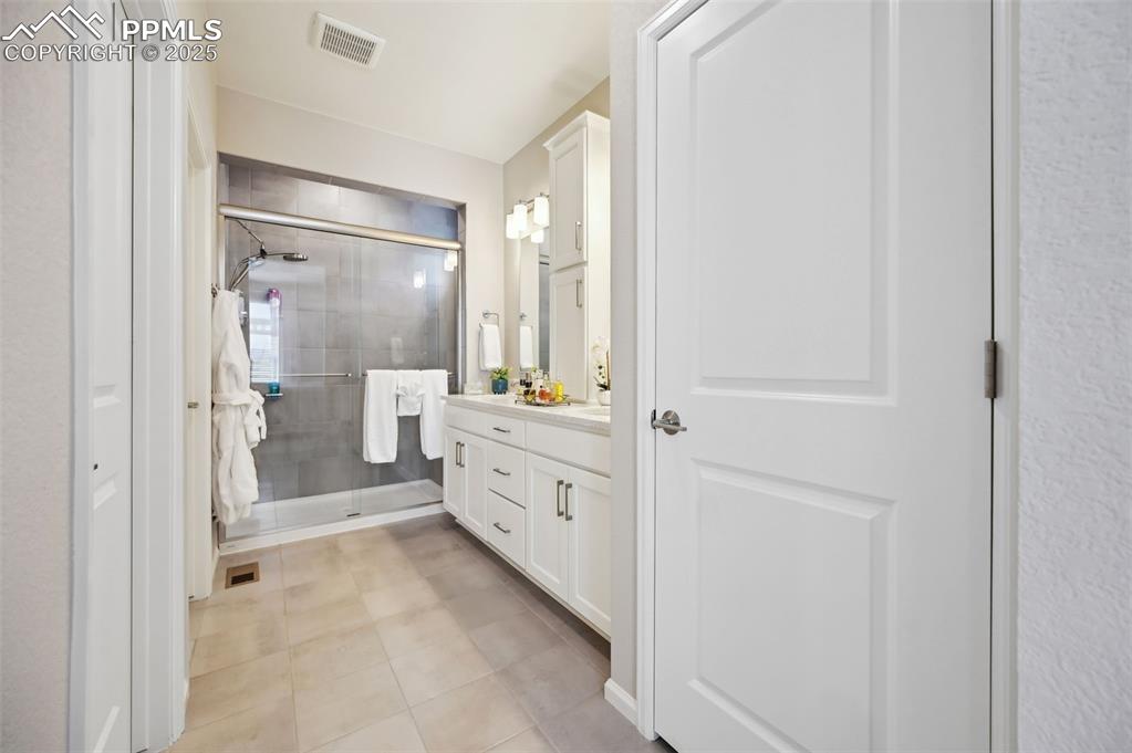 Image 19 of 44: Full bath with a stall shower, vanity, and tile patterned floors