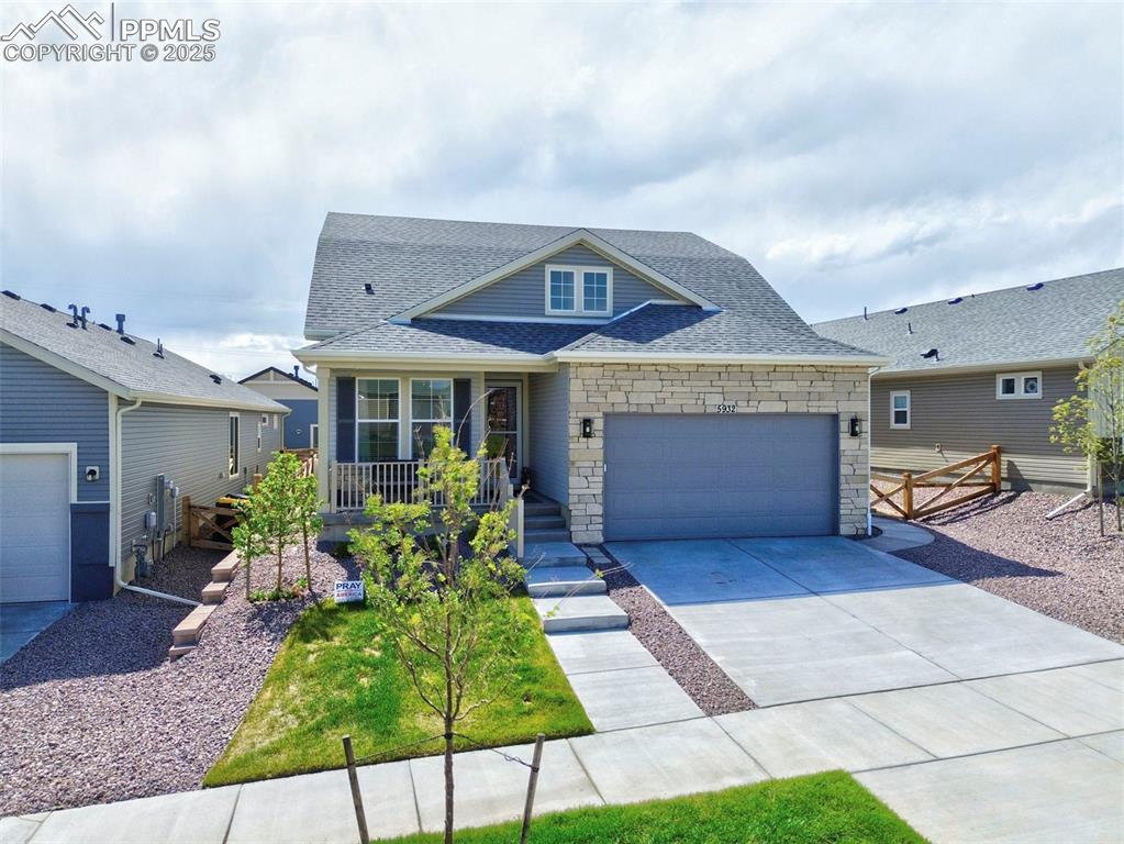 Image 2 of 44: View of front of home with roof with shingles, stone siding, an attached ga