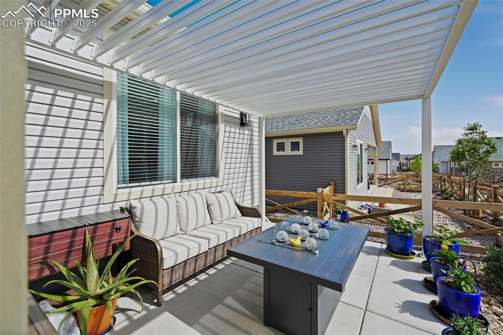 Image 27 of 44: Wooden terrace featuring an outdoor living space and a patio