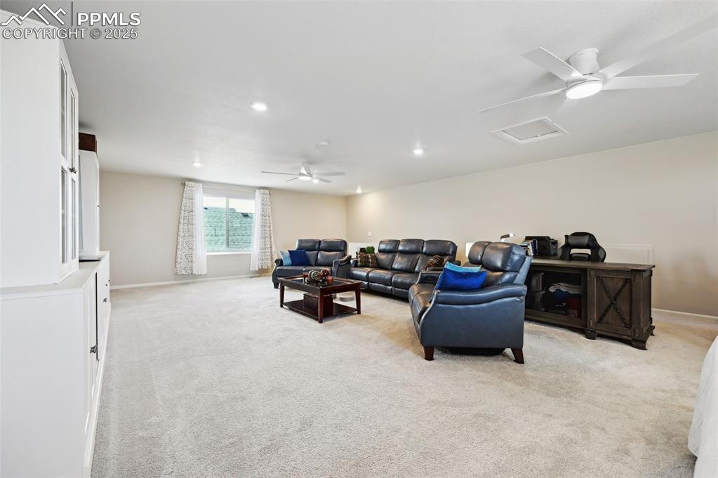 Image 28 of 44: Living area featuring light colored carpet, ceiling fan, recessed lighting,