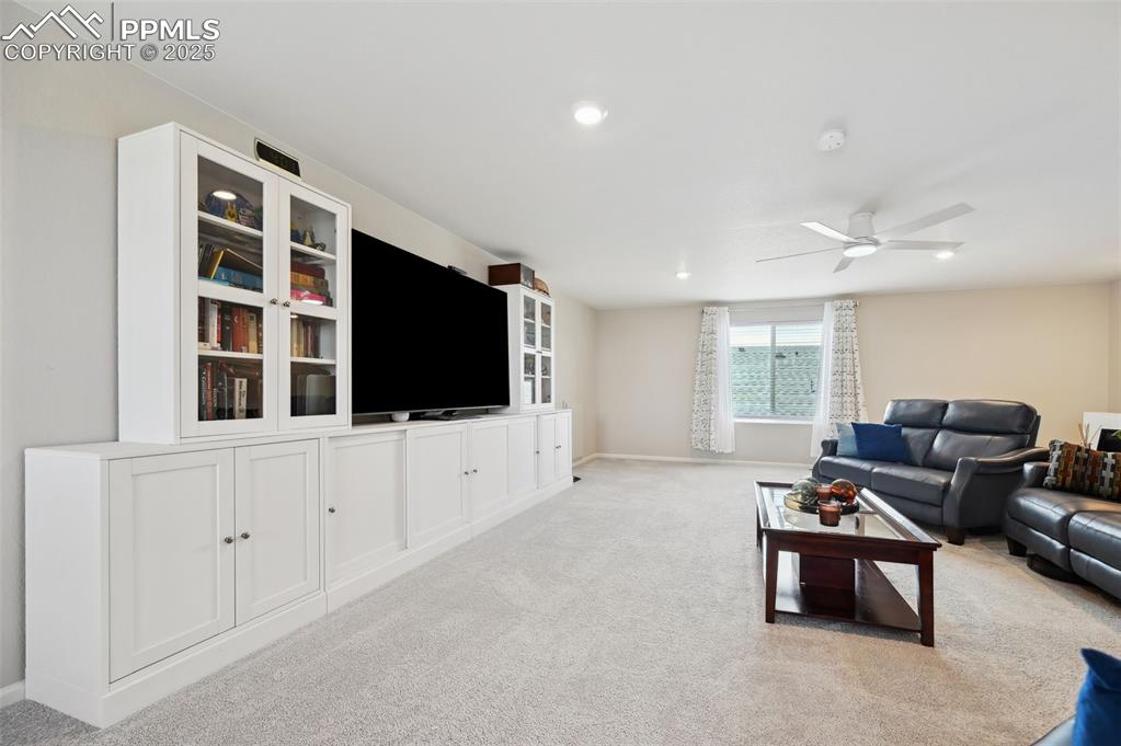 Image 29 of 44: Living room with light colored carpet, baseboards, ceiling fan, and recesse