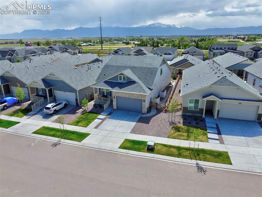 Image 3 of 44: Aerial view of residential area featuring a mountainous background