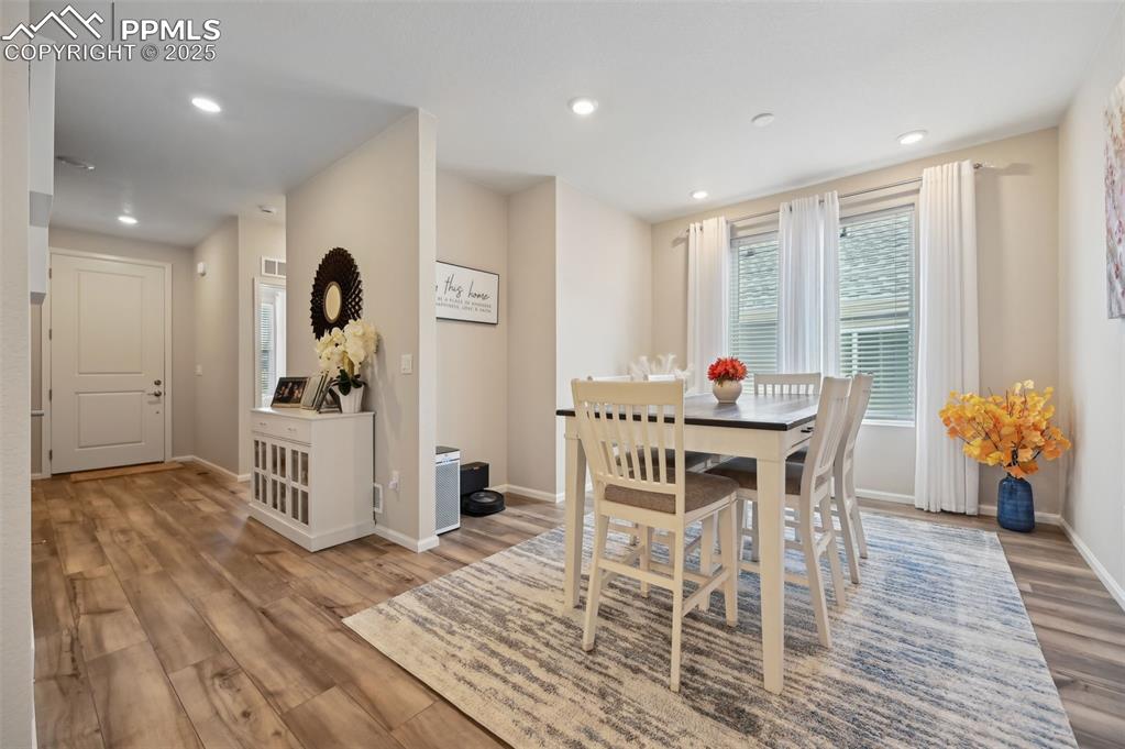 Image 4 of 44: Dining area with wood finished floors, baseboards, and recessed lighting