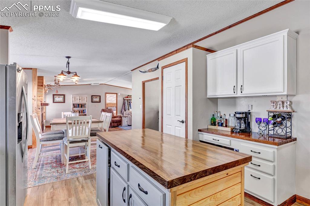 Image 14 of 36: Kitchen with butcher block counters, a textured ceiling, stainless steel fr