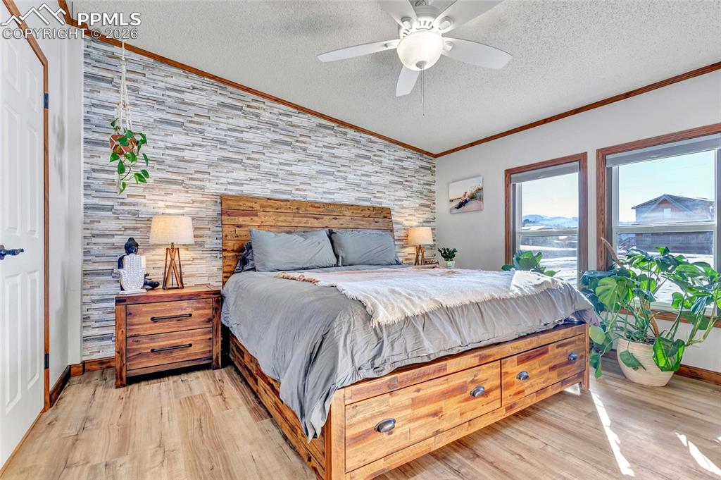 Image 19 of 36: Bedroom with light wood-style flooring, a textured ceiling, ceiling fan, or